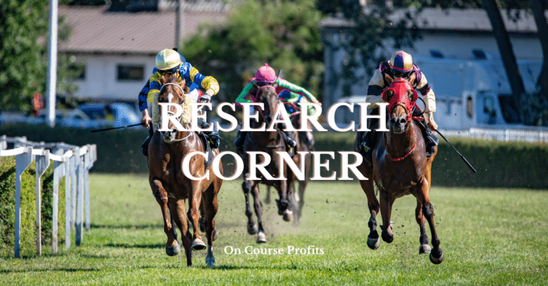 Image shows race horses galloping around a bend on a turf track.