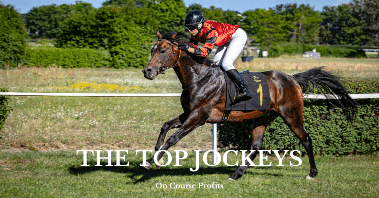 Image shows a jockey in red silks cantering to the start of race on a brown horse.